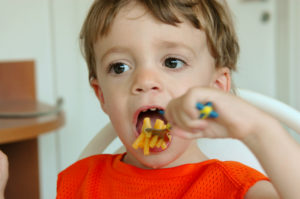 A little boy eats a mac n cheese lunch.